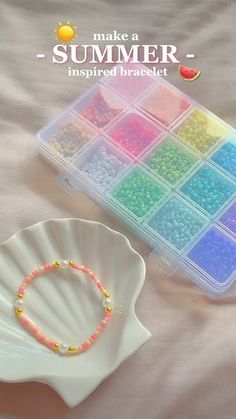 there is a white shell with beads in it next to a small tray of beads