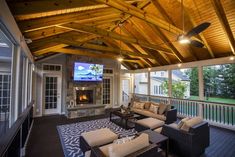 a covered porch with furniture and a flat screen tv