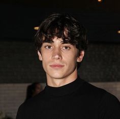 a young man in a black shirt posing for the camera