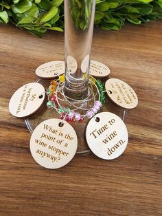 a wine glass filled with lots of different types of magnets on top of a wooden table