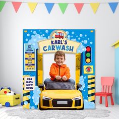 a kid's car wash booth with a little boy sitting in the front seat