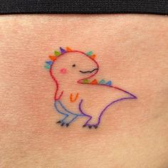 a small tattoo on the back of a woman's stomach with an image of a dinosaur