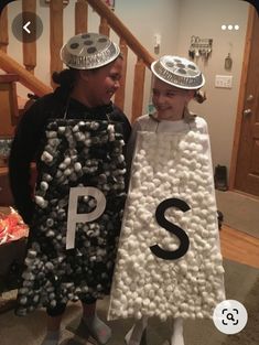 two children dressed up in costumes with letters on them