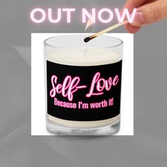 a person holding a match stick in front of a candle with the words self love on it