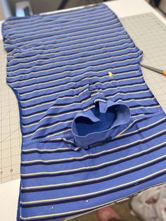 a blue and white striped shirt being sewn