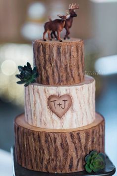 a three tiered cake decorated with deer figurines