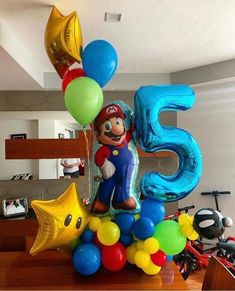 mario birthday decoration with balloons and heliums for the number five in front of him