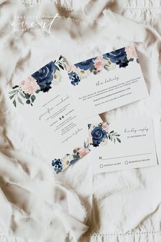 the wedding stationery is laid out on a white sheet with blue and pink flowers