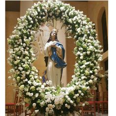 a statue of jesus surrounded by white flowers