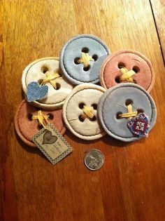 several buttons are sitting on a table next to a penny