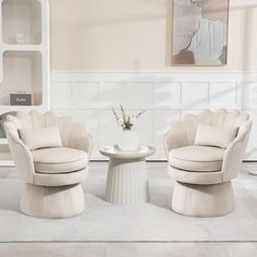 two chairs and a table in a room with white carpeted flooring on the walls