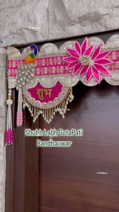 the door is decorated with pink flowers and beads, along with tassels hanging from it