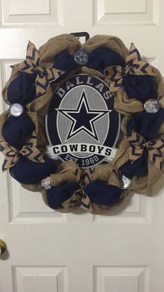 a cowboys wreath hanging on the front door with an army emblem and some decorations around it