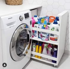 a washer and dryer in a room with white tile flooring next to a shelf filled with cleaning products