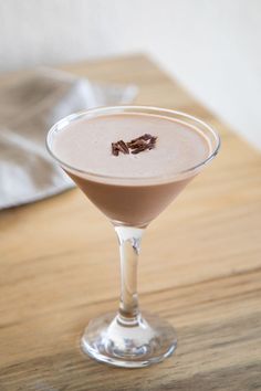 a drink in a martini glass on a wooden table