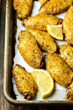 chicken wings with lemon wedges and seasoning on the side, ready to be served