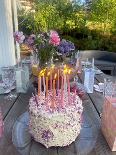 a birthday cake sitting on top of a table with lit candles in the middle of it