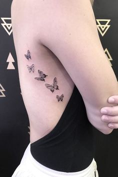 the back of a woman's left shoulder with butterflies on her upper arm and chest