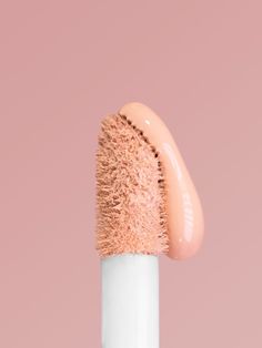 a close up of a pink brush on a white pole with a light pink background