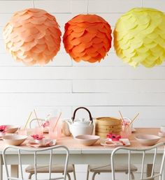 paper lanterns are hanging from the ceiling above a table