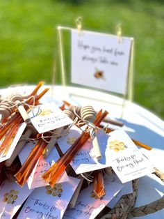 a table topped with lots of cards and wooden stick holders filled with honeybees