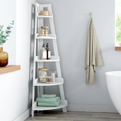 a bathroom with a ladder shelf next to the bathtub