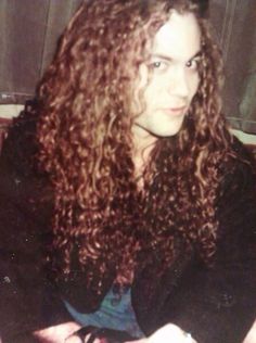 a woman with long curly hair sitting down