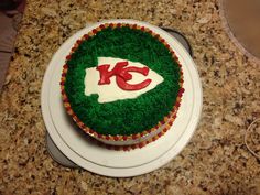 a cake decorated with green frosting and the letter k on it's side