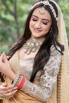 a woman in a bridal outfit is smiling and holding her hand on her hip