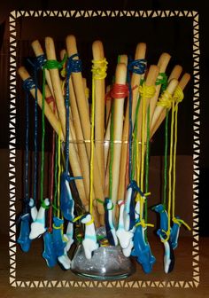 a vase filled with lots of wooden sticks and string tied to it's sides