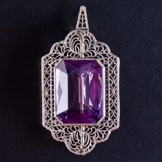 Vintage 1920's 14k White Gold Amethyst Solitaire Brooch Pendant Combo 17.25ctWorn on hats, jacket lapels or on the hip and with sleeveless outfits, this vintage 1920's 14k white gold amethyst brooch added color and class to any outfit back then. With a beautifully cut amethyst and fine filigree surrounding the stone, this brooch is a truly stunning piece, showing us what was popular in the 1920's. Metal Information: 14k White Gold Total Weight: 8.7g Width: 24 MM Length: 39.6 MM Circa: 1920's Sto Elegant Purple Gemstone Brooches, Luxury Purple Brooches For Formal Occasion, Elegant Amethyst Brooches For Wedding, Vintage Gemstone Brooches For Formal Occasions, Purple Brooch Jewelry For Evening, Elegant Purple Brooches For Anniversary, Antique Purple Brooches For Formal Occasions, Antique Purple Formal Brooches, Art Deco Purple Jewelry For Formal Occasions