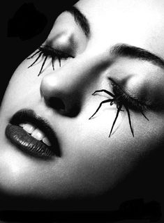 a black and white photo of a woman's face with spider webs on her eyes