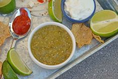 a tray filled with tortilla chips, salsa and guacamole sauce