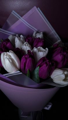 purple and white tulips are arranged in a bouquet