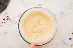 someone is mixing ingredients in a glass bowl