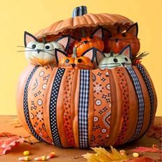 an orange pumpkin decorated with cats sitting in it