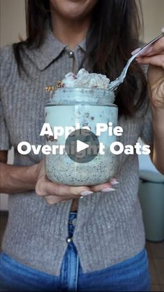 a woman holding a jar filled with oatmeal