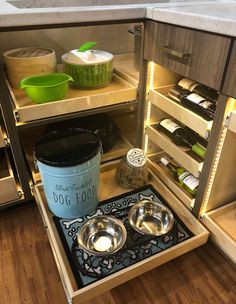 an open refrigerator with two bowls and bottles in it