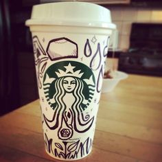 a starbucks cup sitting on top of a wooden table