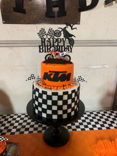 a birthday cake decorated with an orange and black checkered design