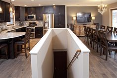 a kitchen and dining room are shown in this image with dark wood cabinets, stainless steel appliances, and marble countertops