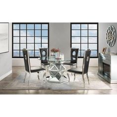 a glass dining table with black chairs and a clock on the wall in front of it