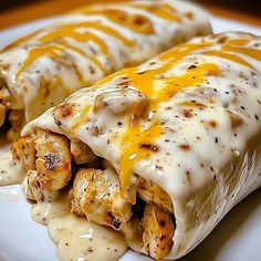 two burritos covered in cheese and sauce on a plate