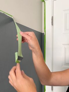 someone is painting the wall with green tape