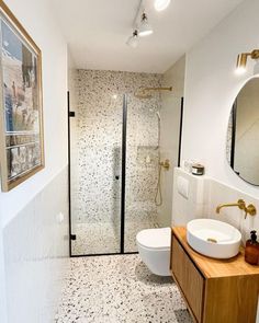 a bathroom with a sink, toilet and shower in it's own area is shown