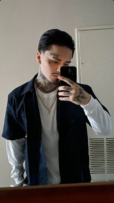 a man taking a selfie in front of a mirror with his hand on his hip