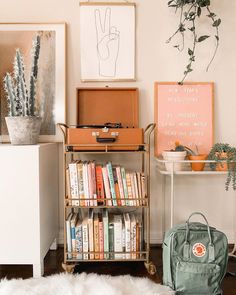 a living room filled with furniture and bookshelves next to a white table topped with plants