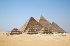 three pyramids in the desert with blue sky