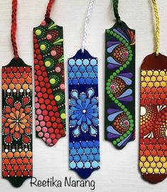 four colorful painted bookmarks hanging from strings on a white background with the words reetika naranig written below them