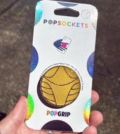 a person holding up a card with a yellow ball on it's front side